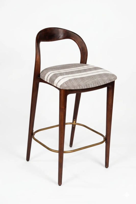 A mid-century modern bar stool with a curved dark wood backrest, a striped upholstered seat cushion in beige and gray, and a brass footrest, shown against a plain white background.