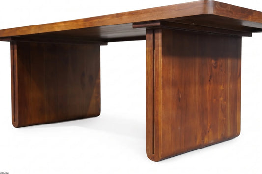 A mid-century modern wooden desk with a warm brown finish, featuring a thick rectangular top and integrated block-style legs, shown on a white background.