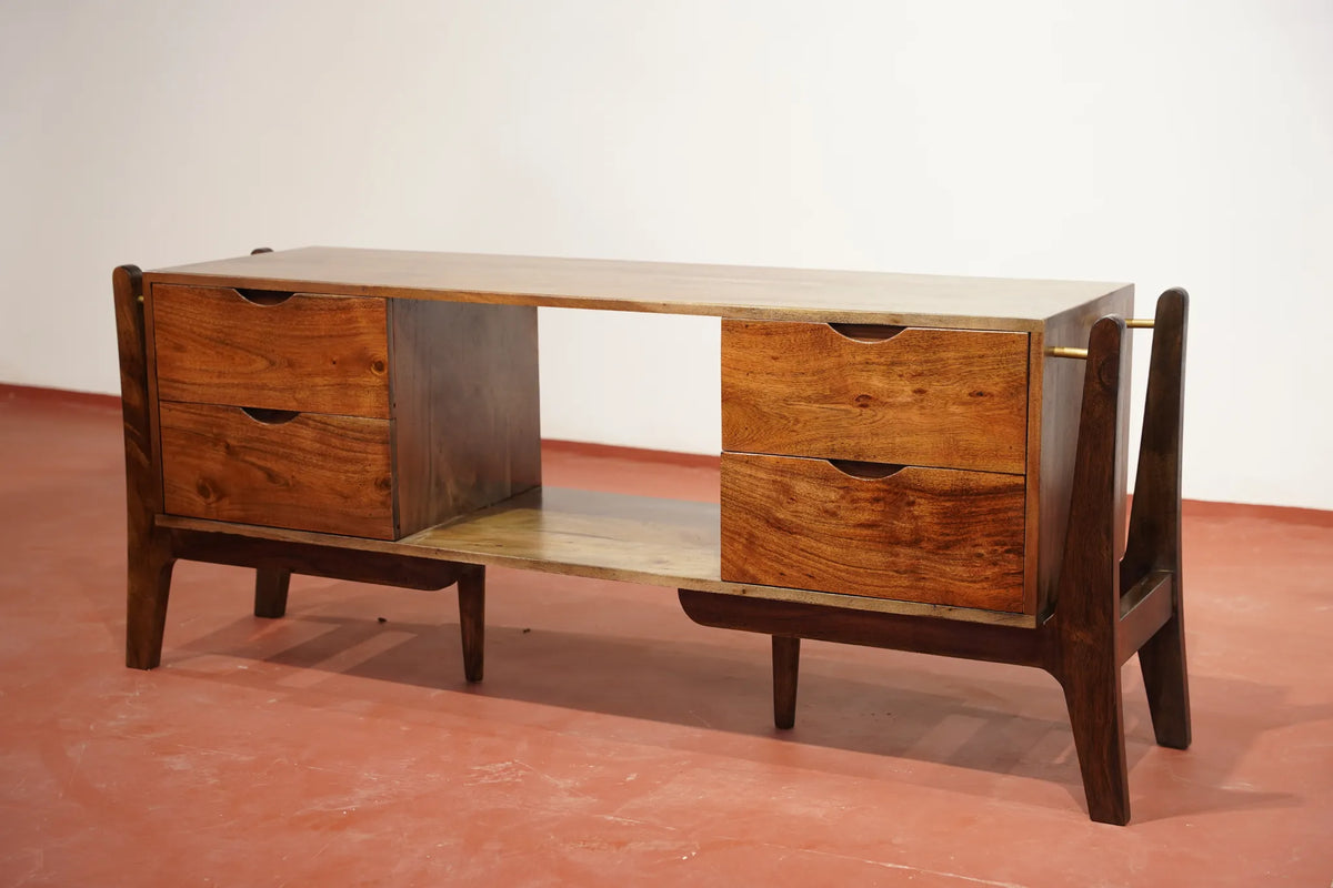 Mid-century modern wooden console table with two drawers on each side, an open center shelf, and a light wood top and lower shelf, shown on a terracotta-colored floor against a white wall.
