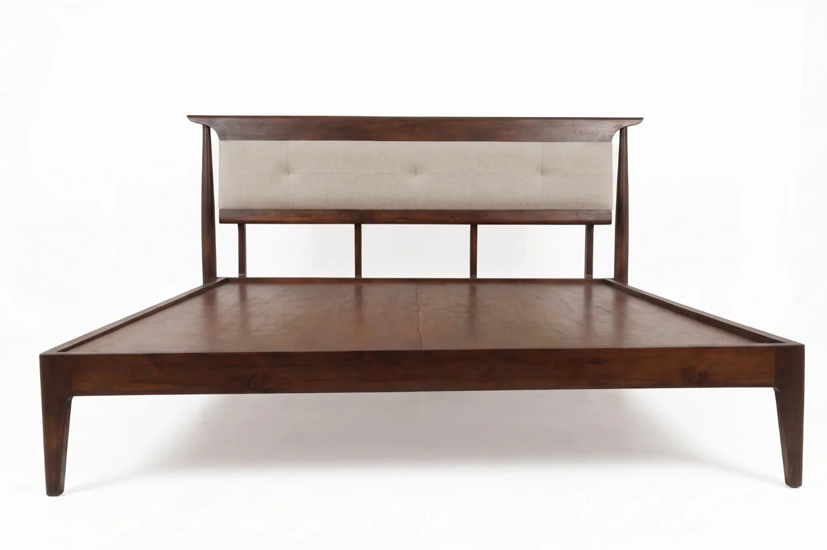 A mid-century modern platform bed frame with a dark brown wood finish, featuring a low headboard with a tufted beige upholstered panel, shown against a plain white background.