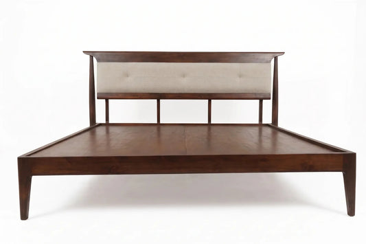 A mid-century modern platform bed frame with a dark brown wood finish, featuring a low headboard with a tufted beige upholstered panel, shown against a plain white background.